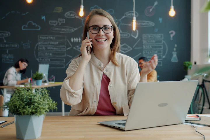 Una consulente sorridente al telefono nel suo ufficio