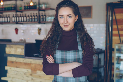 La titolare di un bar, sorridente, nel suo locale